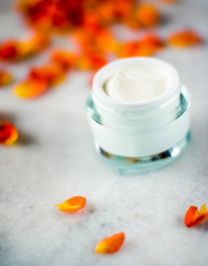 Mermer üzerinde güzellik yüz nemlendirici krem ve çiçek yaprakları, LuXu