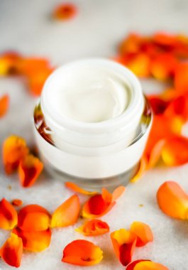 Mermer üzerinde güzellik yüz nemlendirici krem ve çiçek yaprakları, LuXu