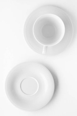 Beyaz arka plan üzerinde boş fincan ve tabak mockup, flatlay