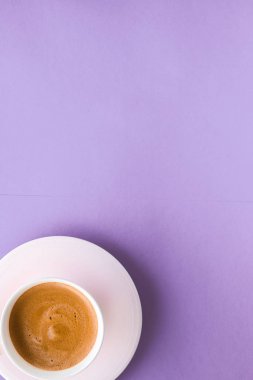 Coffee cup on purple background, top view flatlay