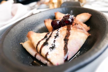 Bir reastaurant çikolata sosu ve kiraz ile Fransız krep