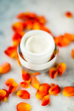 Mermer üzerinde güzellik yüz nemlendirici krem ve çiçek yaprakları, LuXu