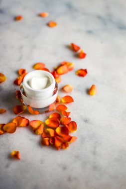 Mermer üzerinde güzellik yüz nemlendirici krem ve çiçek yaprakları, LuXu