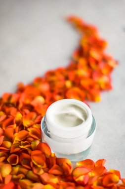 Mermer üzerinde güzellik yüz nemlendirici krem ve çiçek yaprakları, LuXu