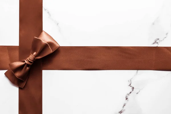 Шоколадно-коричнева шовкова стрічка на мармуровому фоні, плоска — стокове фото
