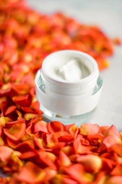 Mermer üzerinde güzellik yüz nemlendirici krem ve çiçek yaprakları, LuXu