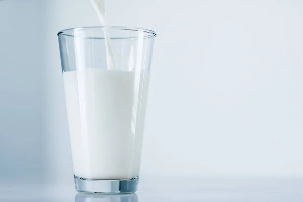 Día Mundial de la Leche, vertiendo en el vidrio sobre la mesa de mármol — Foto de Stock