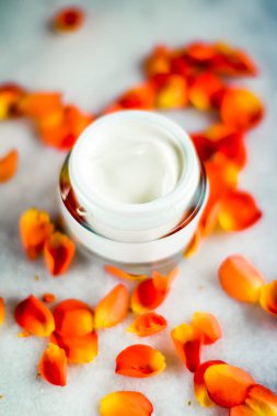 Mermer üzerinde güzellik yüz nemlendirici krem ve çiçek yaprakları, LuXu