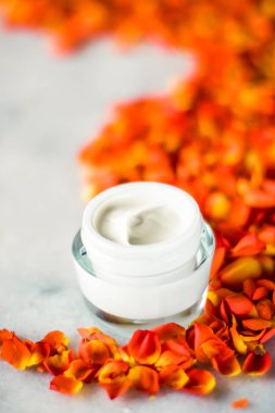 Mermer üzerinde güzellik yüz nemlendirici krem ve çiçek yaprakları, LuXu