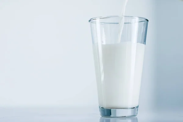 Giornata Mondiale del Latte, versando in vetro sul tavolo di marmo — Foto Stock