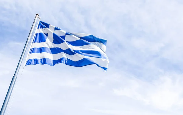 Greek flag and cloudy sky in summer day, politics of Europe