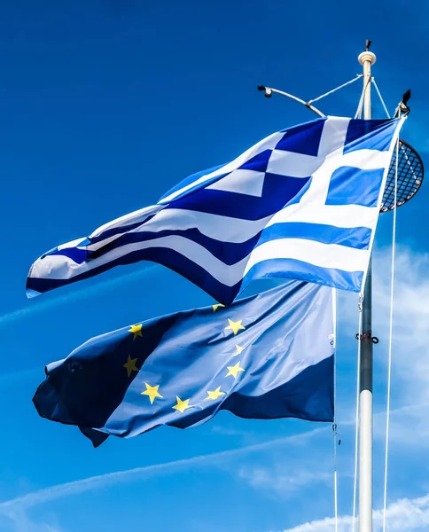 Flagi Grecji i Unii Europejskiej na tle błękitnego nieba, polit — Zdjęcie stockowe