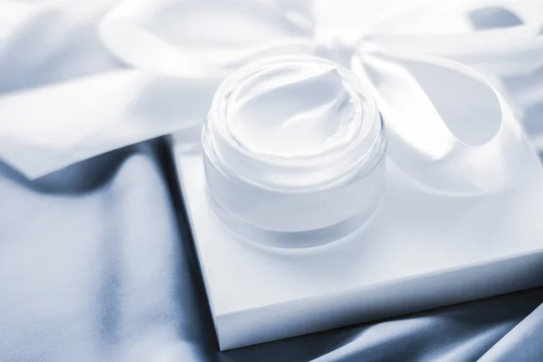 Moisturizing beauty face cream and gift box on soft blue silk