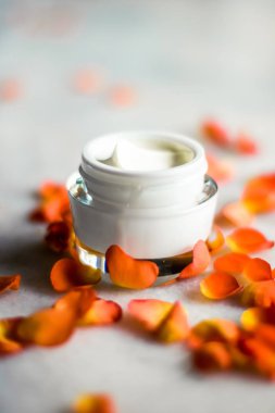 Mermer üzerinde güzellik yüz nemlendirici krem ve çiçek yaprakları, LuXu