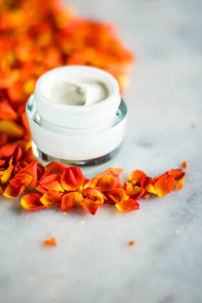 Crema hidratante de la cara de belleza y pétalos de flores en mármol, luxu — Foto de Stock