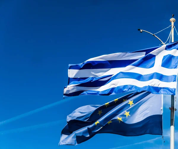 Flagi Grecji i Unii Europejskiej na tle błękitnego nieba, polit — Zdjęcie stockowe