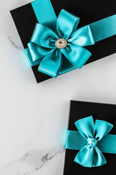 Luxus üdülési ajándékok smaragd selyemszalaggal és íjjal a márvány — Stock Fotó