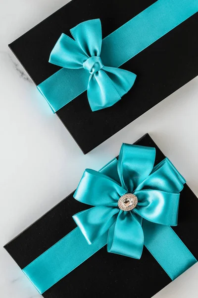 Luxury holiday gifts with emerald silk ribbon and bow on marble