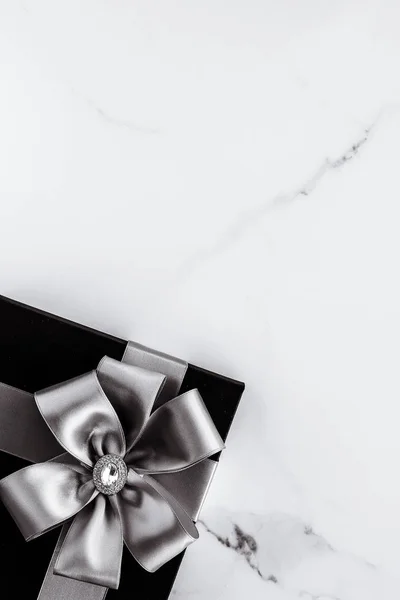 Regali di festa di lusso con nastro di seta argento e fiocco su b marmo — Foto Stock