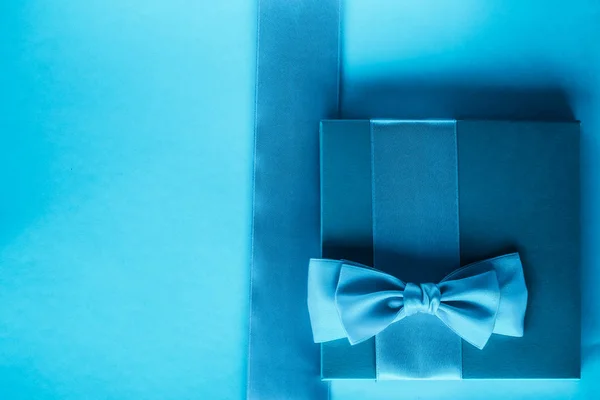 Presentes de férias de luxo com fita de seda e arco no fundo azul — Fotografia de Stock
