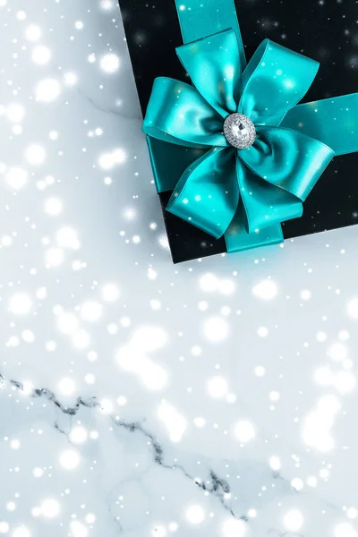 Winter holiday gifts with emerald silk bow and glowing snow on f — Stock Photo, Image