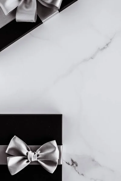Regali di festa di lusso con nastro di seta argento e fiocco su b marmo — Foto Stock