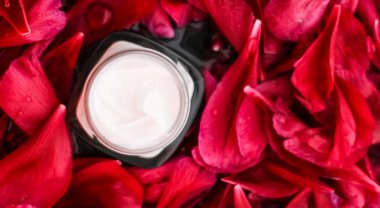 Kırmızı çiçek yaprakları ve WA Hassas Cilt Bakımı nemlendirici krem