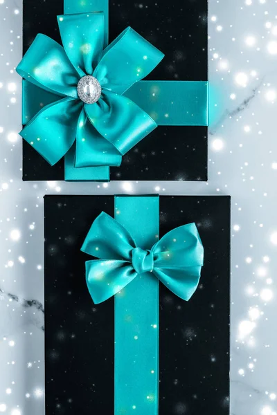 Winter holiday gifts with emerald silk bow and glowing snow on f — Stock Photo, Image