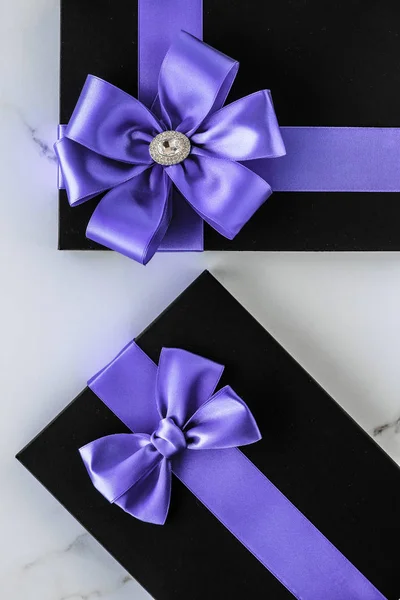 Luxus-Weihnachtsgeschenke mit Lavendelseidenband und Schleife auf Marmor — Stockfoto