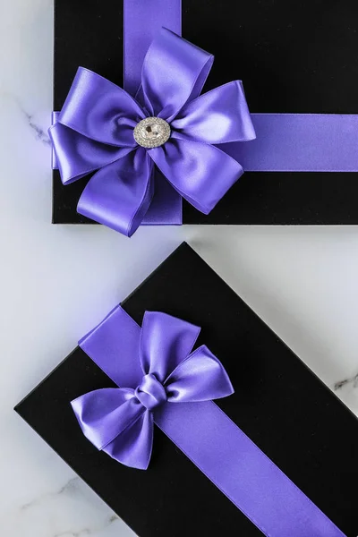 Luxury holiday gifts with lavender silk ribbon and bow on marble