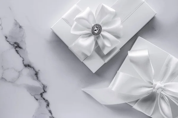 大理石のバックグロにシルクの弓とリボンを持つ豪華な結婚式の贈り物 — ストック写真