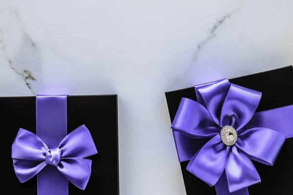 Luxury holiday gifts with lavender silk ribbon and bow on marble — Stock Photo, Image