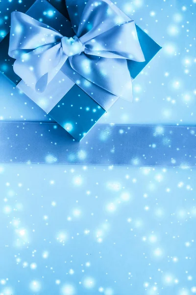Vintersemester gåvor och glödande snö på fryst blå bakgrund, — Stockfoto