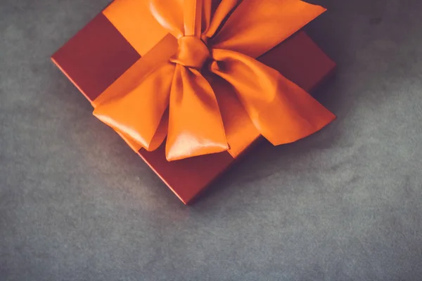 Vintage luxury holiday orange gift box with silk ribbon and bow,