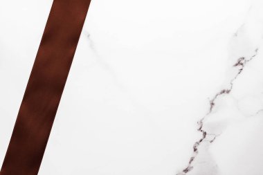 Mermer zemin üzerinde çikolata kahverengi ipek kurdele, düz zemin