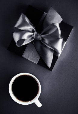 Siyah yatık artalan üzerinde lüks kahve markası, fincan ve hediye kutusu
