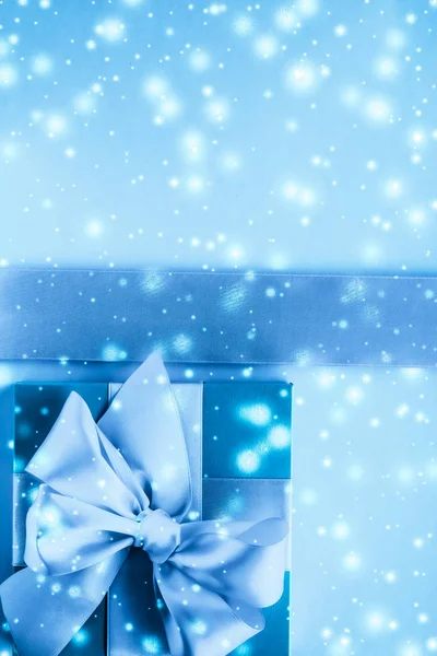 Kış tatili hediyeleri ve dondurulmuş mavi arka planda parlayan kar, — Stok fotoğraf