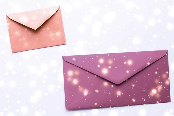 Winter holiday blank paper envelopes on marble with shiny snow f