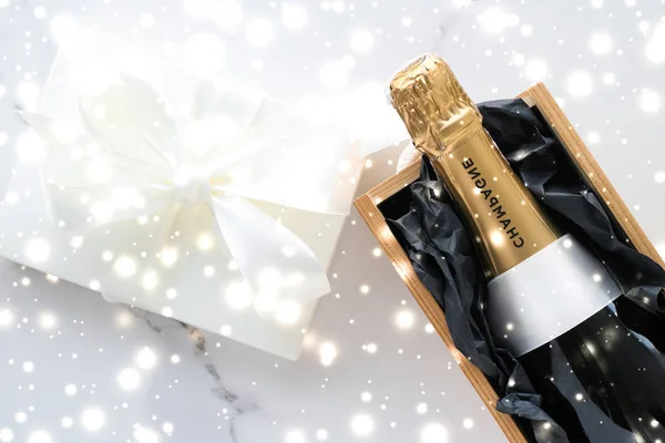 Bouteille de champagne de Noël et boîte cadeau et neige brillante — Photo