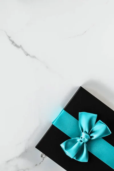 Lyx semester gåvor med smaragd sidenband och rosett på marmor — Stockfoto