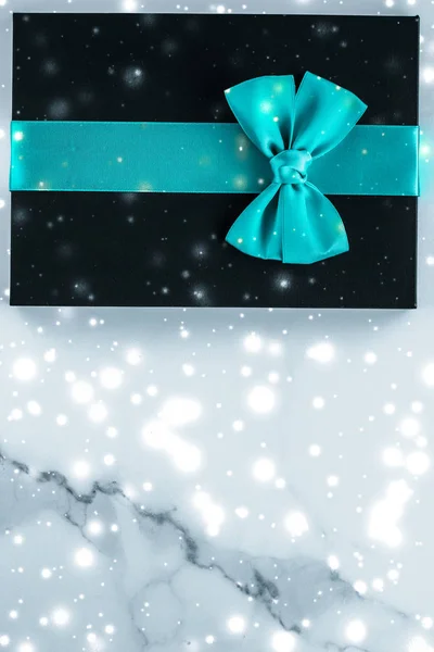 Regalos de vacaciones de invierno con arco de seda esmeralda y nieve brillante en f —  Fotos de Stock