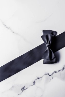 Siyah ipek kurdele ve yay mermer arka planda, yatık