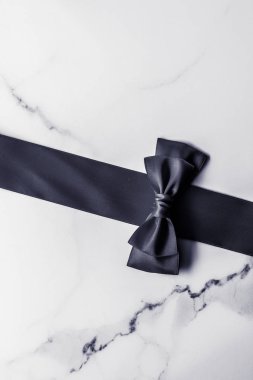 Siyah ipek kurdele ve yay mermer arka planda, yatık