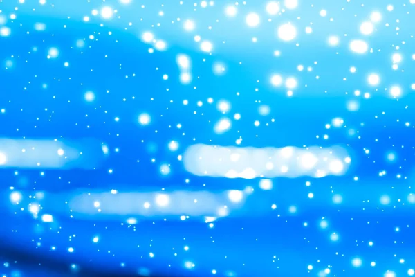 Winter holiday abstract background, glowing snow and magic spark