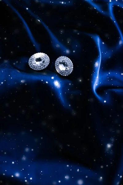 Роскошные бриллиантовые серьги на темно-синем шелке с блестками от снега, хол — стоковое фото