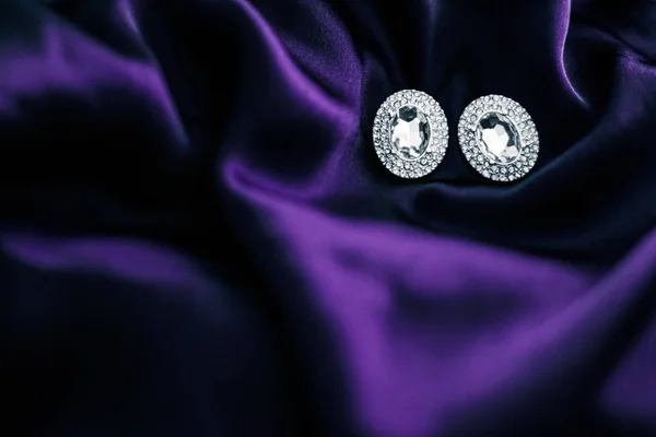 Pendientes de diamantes de lujo en tela de seda violeta oscura, glam navideño —  Fotos de Stock