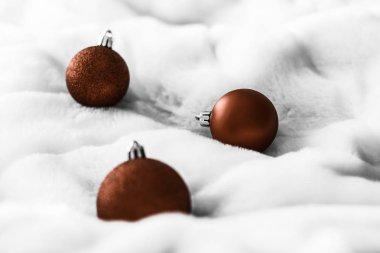 Beyaz kabarık kürk zemin üzerinde Çikolata kahverengi Noel baubles, 
