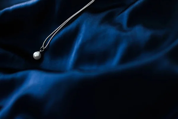 Πολυτέλεια λευκό χρυσό μαργαριτάρι κολιέ σε σκούρο μπλε μετάξι φόντο, h — Φωτογραφία Αρχείου