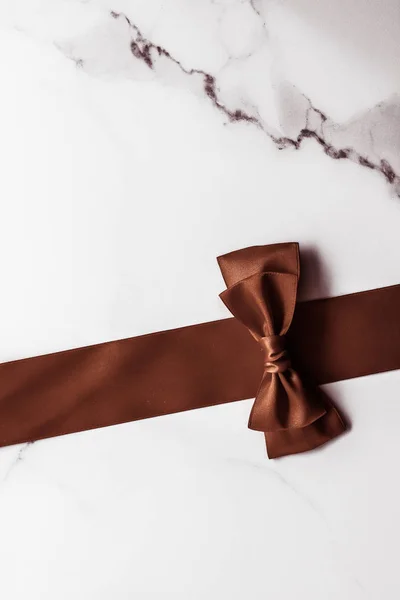 Čokoládová hnědá hedvábná stuha na mramorovém pozadí, ploché — Stock fotografie