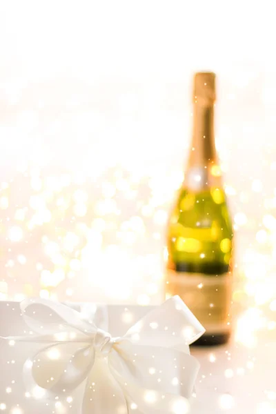 New Years Eve holiday champagne bottle and a gift box and shiny — Stock Photo, Image